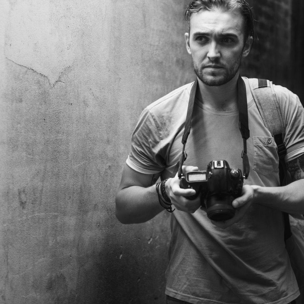 Fotógrafo caucásico con su cámara en la mano.