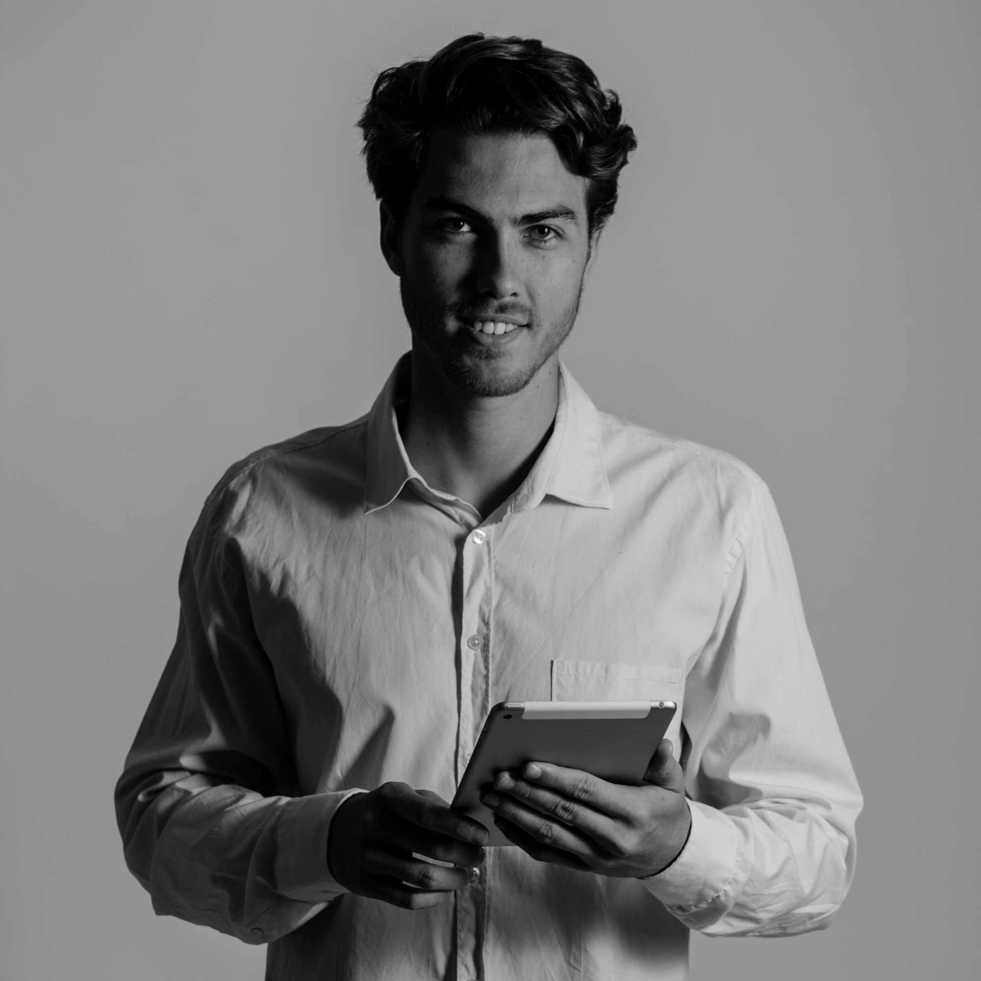 Hombre sonriente con una tablet en la mano.